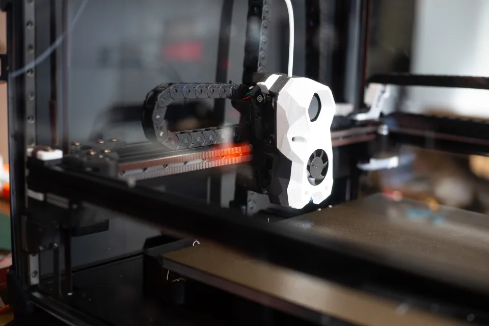 Enclosed 3D printer with its print head over the build plate