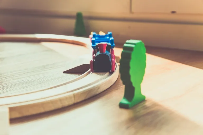 Handmade wooden toy train on a curved wooden track