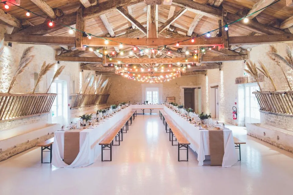 Long banquet tables and benches set up in a rustic event hall