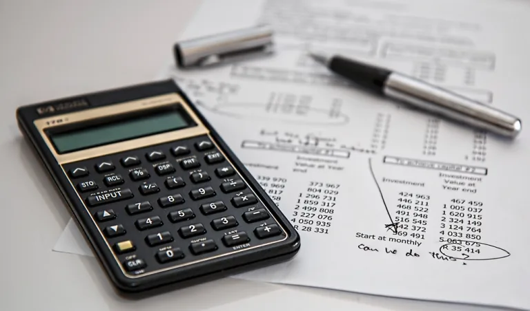 Calculator and pen resting on a printed budget worksheet