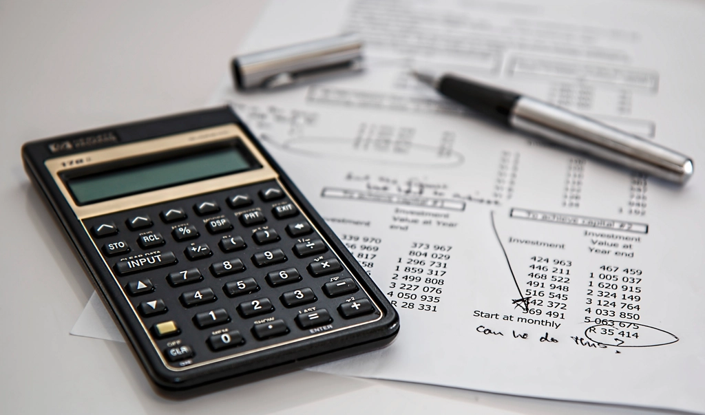 Calculator and pen resting on a printed budget worksheet