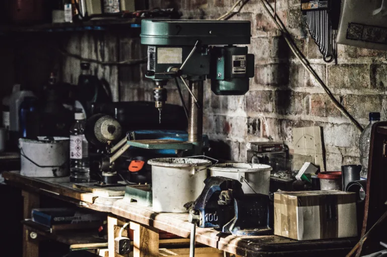 Garage workbench with a drill press, bench vise and repair supplies