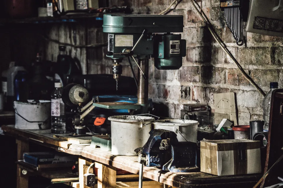Garage workbench with a drill press, bench vise and repair supplies