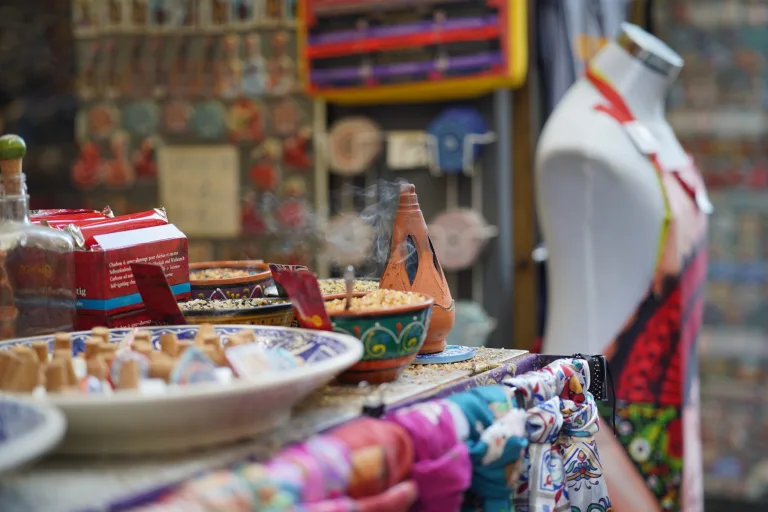 Market stall displaying handmade ceramic bowls and colorful textiles