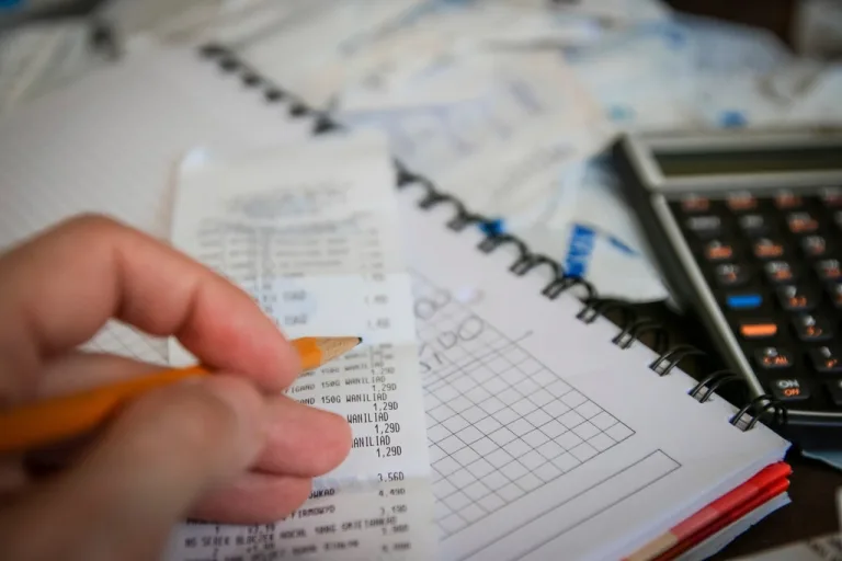 Receipts, notebook and calculator for small business bookkeeping