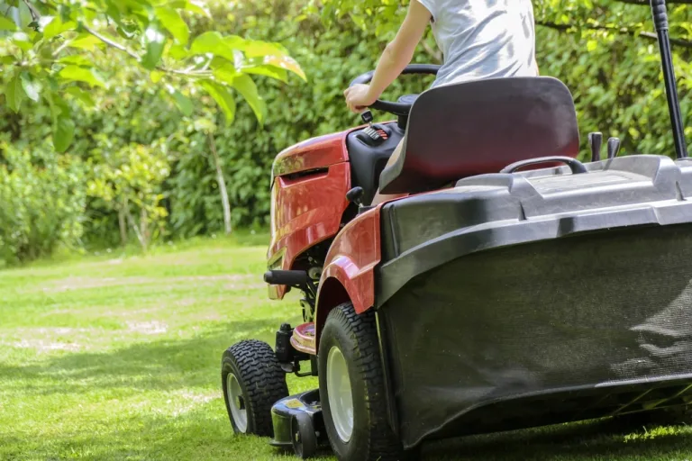 Red riding lawn mower on a green lawn
