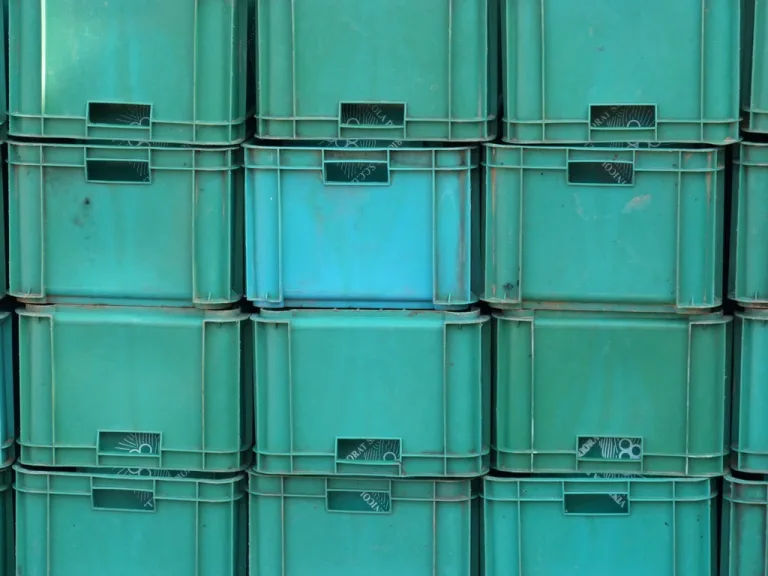 Stacks of green plastic crates lined up in rows