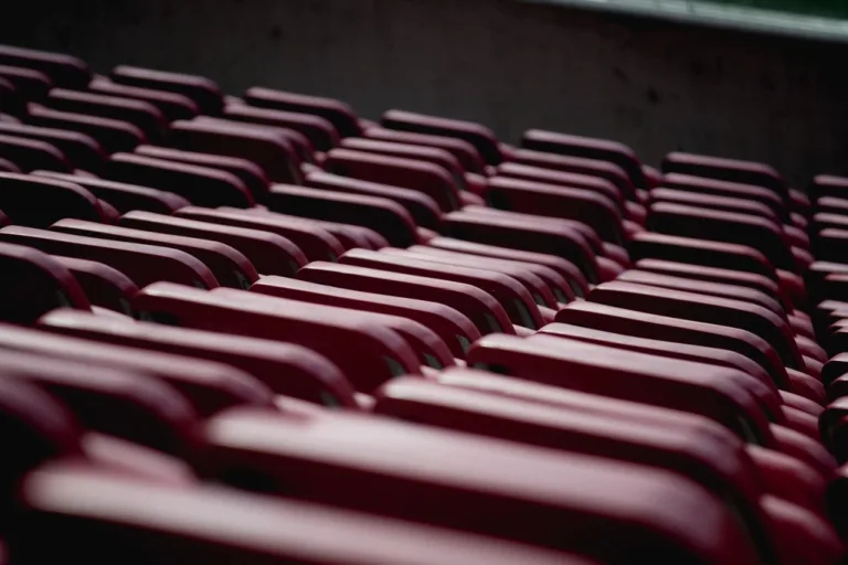 Rows of folded red chairs stacked in storage