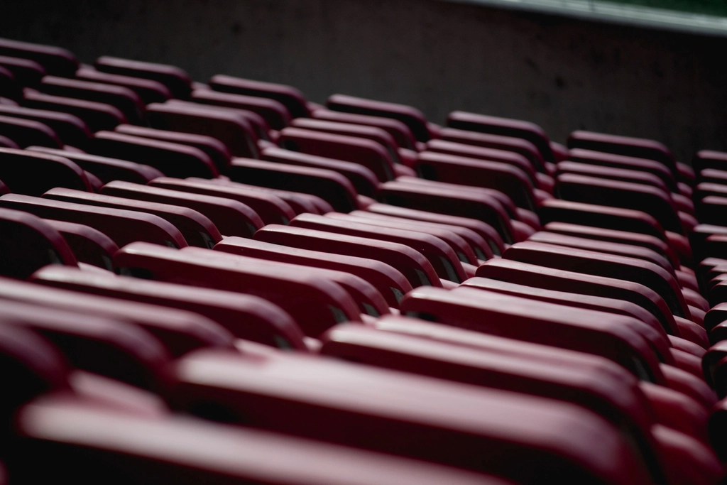 Rows of folded red chairs stacked in storage