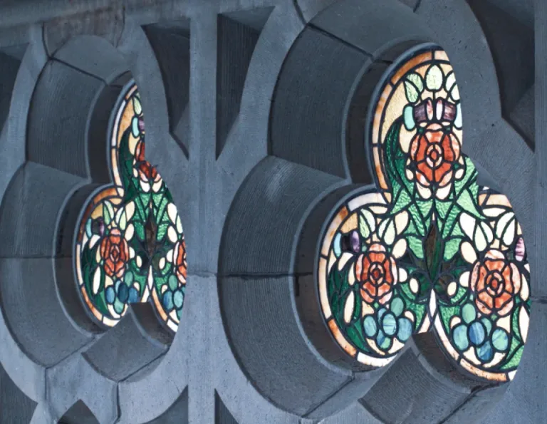 Colorful leaded stained glass panels set in stone window frames
